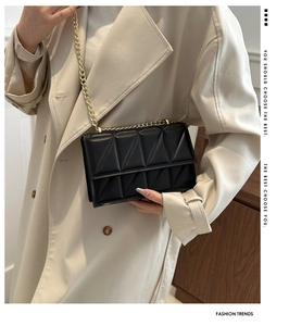 Close-up of black quilted PU leather crossbody bag with elegant gold chain strap