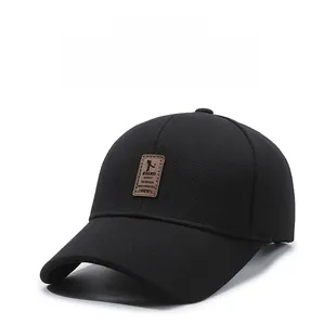 Detail of black baseball cap showing breathable texture and brown leather patch logo