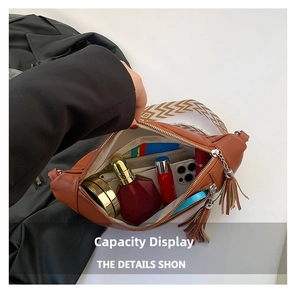 Detail view of brown leather crossbody bag interior showing storage for phone and cosmetics