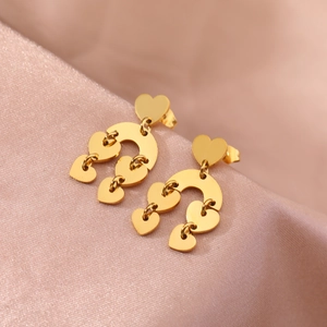 Elegant gold layered heart dangle earrings on a luxury pink silk background