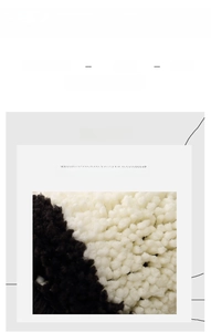 Close-up of thick black and white plush fabric showing dense tufted rug texture