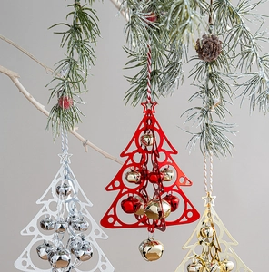 Hollow metal Christmas tree ornaments with colorful bells hanging on pine branches