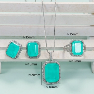 Emerald cut turquoise jewelry set with necklace, studs, and ring on white tray