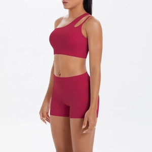 Detail von rotem One-Shoulder Sport-BH und Yoga-Shorts mit hoher Taille am Model