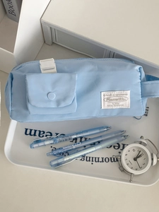 Detail of light blue padded pencil case with matching gel pens in a desktop organizer