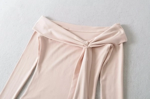 Detail of the knot design and off-shoulder neckline on a pink long sleeve top