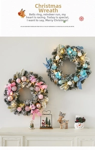 Detail of pink and blue Christmas wreaths with warm LED lights and artificial snow texture