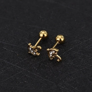 Detailed macro view of gold umbrella stud earrings with sparkling cubic zirconia stones