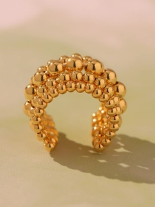 Macro shot of multi-layer polished gold beaded ring with a wide geometric open design