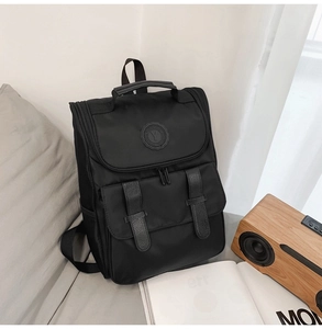 Detailed view of black nylon backpack with PU leather straps and magnetic buckles