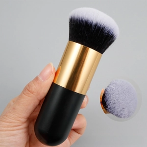 Macro detail of dense synthetic bristles on a black and gold portable foundation brush