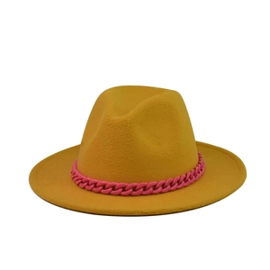Detail of yellow wool fedora hat featuring a chunky pink plastic chain decoration