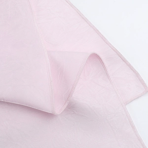 Detailed view of pale pink satin fabric showing high-quality hemmed edges and texture