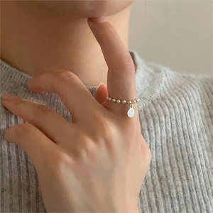 Detailed view of a 925 sterling silver beaded ring with a smooth round pendant on a finger