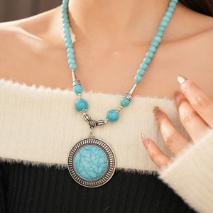 Detail showing vintage bohemian turquoise pendant and intricate silver carved metalwork
