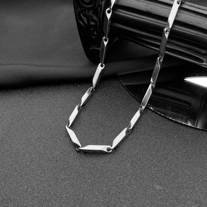 Détail d'un collier chaîne losange argenté avec des maillons en acier poli