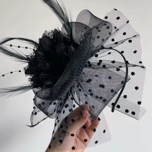 Detail of black polka dot mesh fascinator with elegant feathers and headband
