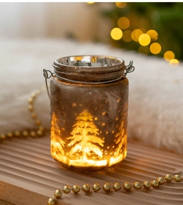 Détail du photophore de Noël en verre avec motif givré posé sur un plateau en bois