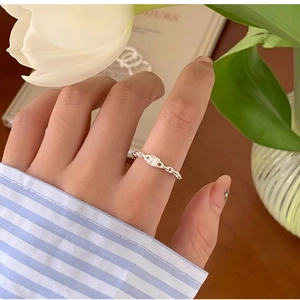 Detail of silver chain ring featuring a rectangular zircon stone worn on a finger