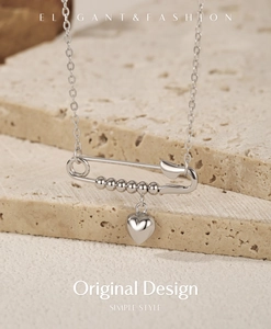 Detail of S925 sterling silver paperclip necklace with polished beads and heart pendant