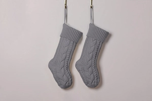 Close-up of gray cable knit Christmas stockings featuring classic braided texture and loops
