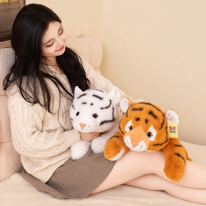 Realistic stuffed tiger plush toy in white and orange lying on a soft cream carpet