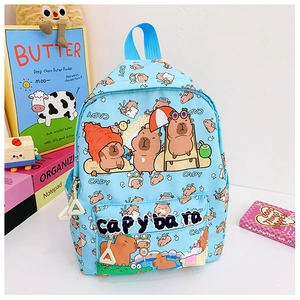 Close-up of light blue kids backpack with Capybara patterns among school stationery