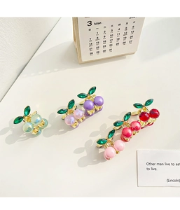 Detailed shot of cherry alloy hair clips with colorful resin beads and rhinestone leaves