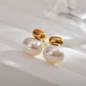 Macro view of vintage pearl stud earrings with elegant gold oval metal detailing
