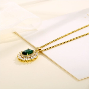 Gold oval green stone pendant necklace with shimmering cubic zirconia around the main gem
