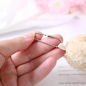Macro detail of plush bear keychain showing soft fur texture and silver bead chain