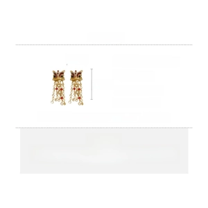 Détail de boucles d'oreilles lion avec zircons et longs glands de perles pour femmes