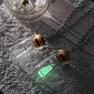 Macro detail of glowing ghost necklaces in corked glass bottles with silver chains