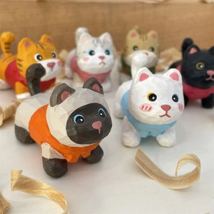 Close-up of hand-carved wooden cat figurines with colorful painted outfits for desk decor