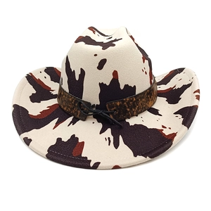 Top view of a cream-colored western cowboy hat with brown cow print and leopard band