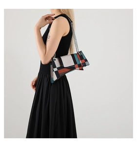 Detail of geometric patchwork leather handbag with silver chunky metal chain strap