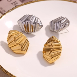 Détail macro de boucles d'oreilles dorées et argentées à texture coquillage