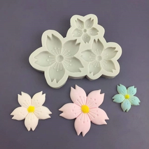 Detailed view of white cherry blossom silicone mold with pink and blue floral fondant shapes