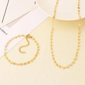 Close-up of gold-plated stainless steel disc chain necklace and bracelet jewelry set