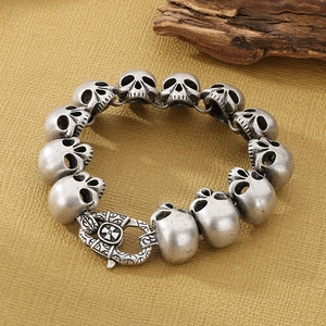 Macro detail of gothic skull link bracelet in vintage silver finish on rustic background