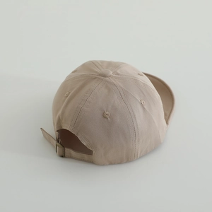 Detail view of khaki cotton baby baseball cap showing adjustable metal buckle and stitching