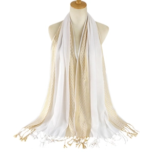 Close-up of white and gold fringed scarf texture with vertical metallic jacquard weave