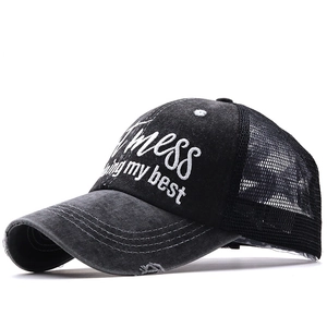 Close-up of distressed brim and embroidery on black ponytail mesh baseball cap