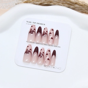 Long almond cat eye press-on nails with red heart and ribbon bow on white tray