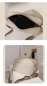 Detail of cream pebbled leather crossbody bag with striped wide strap and silver zipper