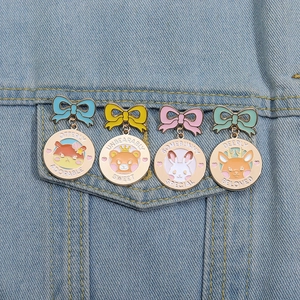 Detail von vier niedlichen Cartoon-Tier-Emaille-Pins auf blauem Denim-Hintergrund
