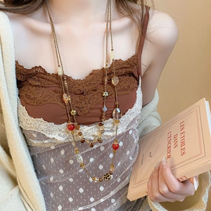 Macro detail of vintage multilayer long beaded necklace with floral and crystal charms