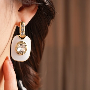 Gros plan sur boucle d'oreille vintage dorée avec diamant sur incrustation carrée