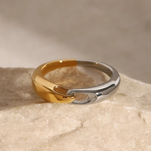 Macro shot of two-tone polished stainless steel ring on natural stone texture