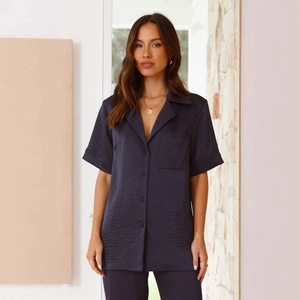 Detail of navy blue satin loungewear set featuring short sleeve shirt and long pants